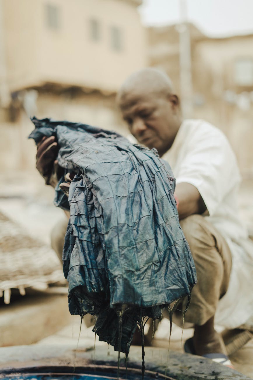man working in a tannery crouching and holding leather